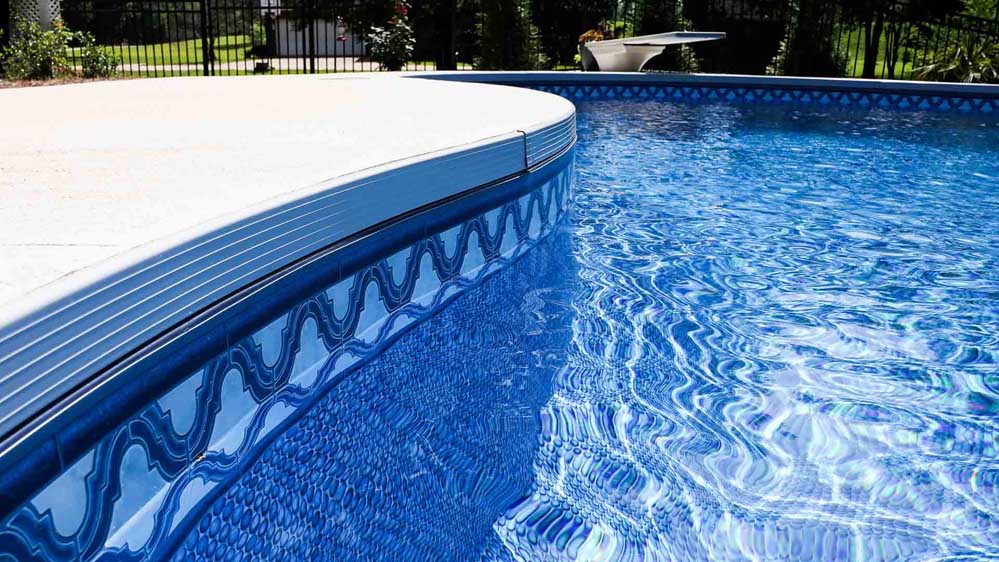A backyard in Mississippi features a beautiful, serene pool created by Aqua + Oak.